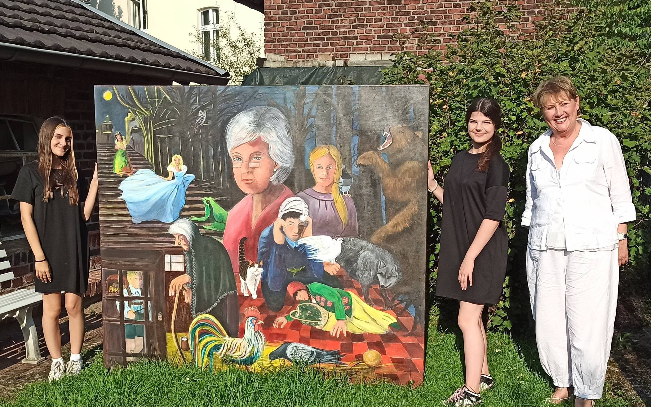  Victoria Nuss (li) und Marta Jastrzebski (re) waren sich beide einig: das große Märchenbild der Künstlerin Claudia Birkheuer (2. v. re) musste auf das Pressefoto. 