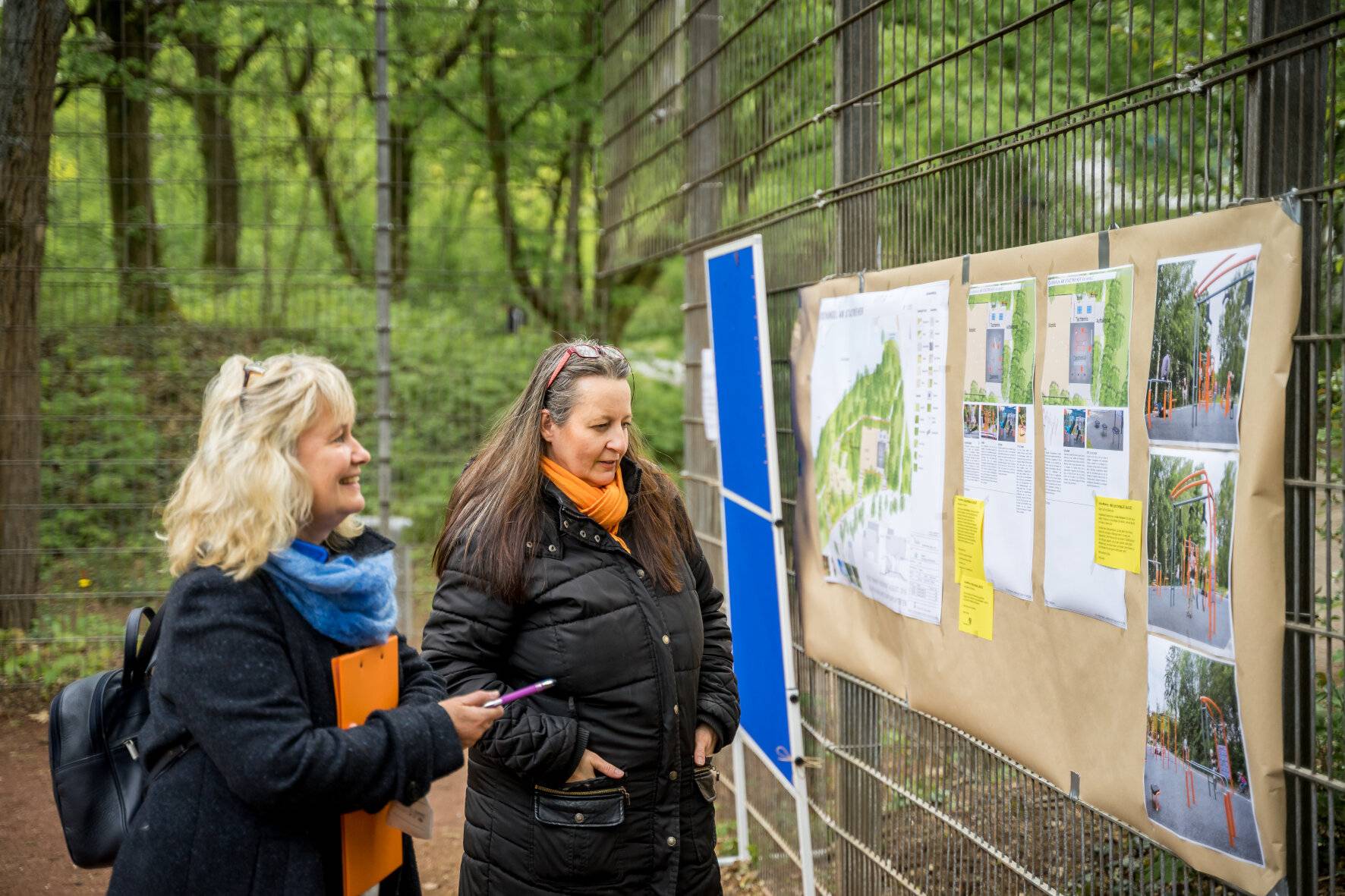  Silke Dietz von der AWO und Claudia Andraczek vom TSV Hochdahl begutachten die Pläne für die neue Calisthenics-Anlage in der Sandheide am Tag der Städtebauförderung.  