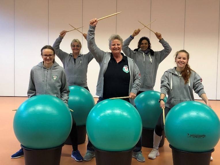 Fitness durch Trommel mit Drum Sticks auf dem Pezziball