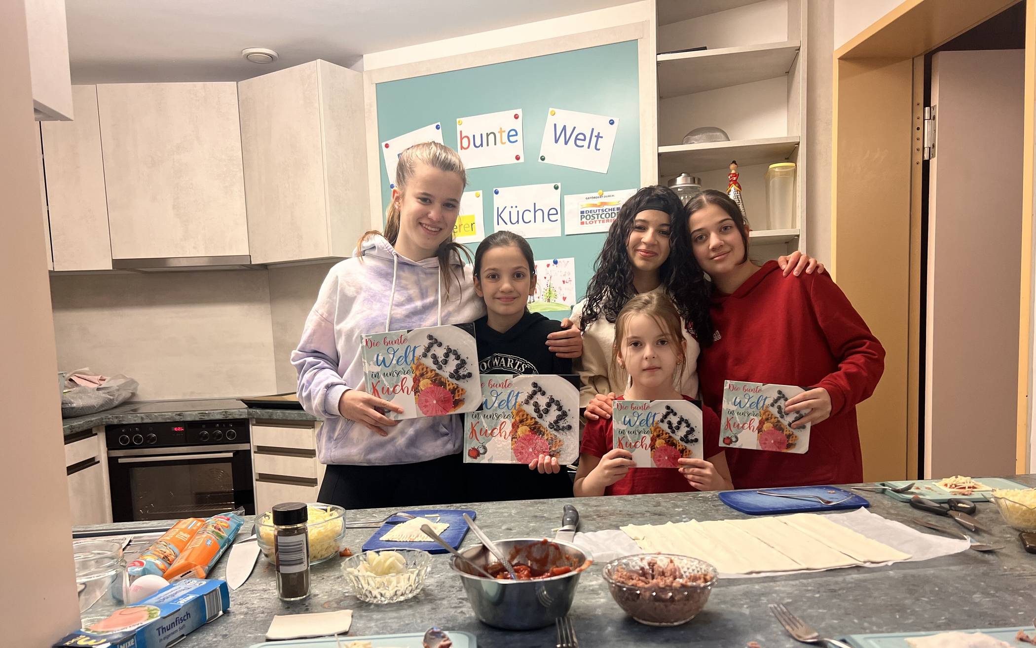  Jungköche im Einsatz: Seit 2021 gibt es den Kochclub im Kinder- und Jugendzentrum des TSV Hochdahl. Nun gibt es sogar ein eigenes Kochbuch, welches die jungen Damen hier stolz präsentieren. 