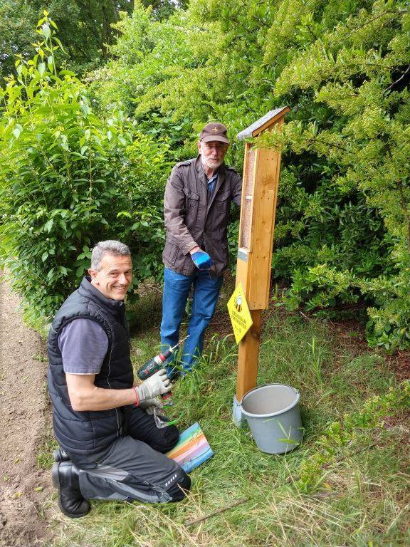  Mitglieder von Unterfeldhaus AKTIV beim Einrichten eines Insektenhotels auf der frisch eingesäten Wildblumenwiese. 