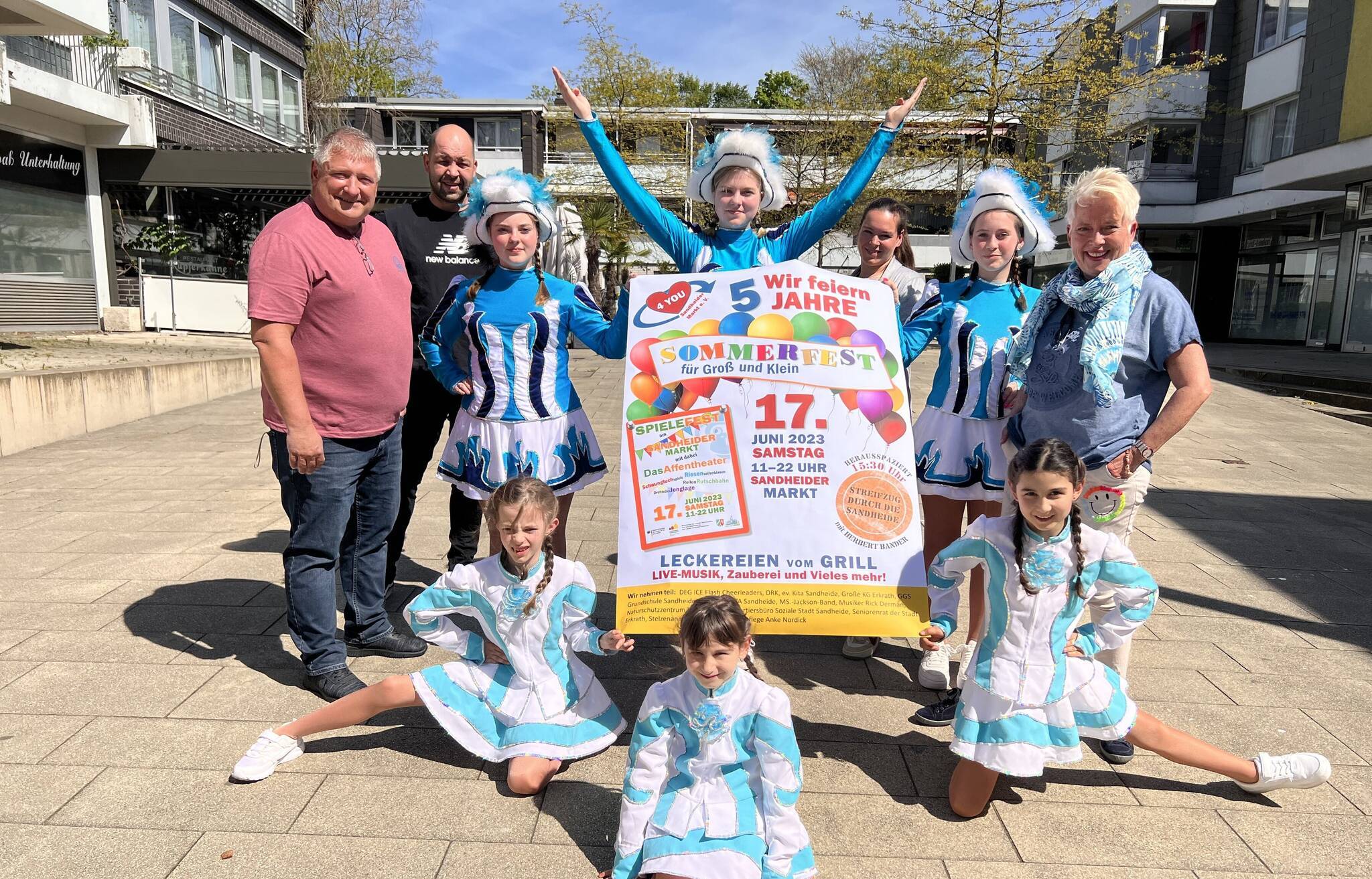 (v.li.) Peter Urban (Vorsitzender Sandheider Markt 4 you), Marco und Nadine Viduca und Mary Niemeyer (alle Orga-Team Sommerfest) gemeinsam mit den Hoppedötzen der Großen Erkrather KG freuen sich auf das bevorstehende Sommerfest auf dem Sandheider Markt.