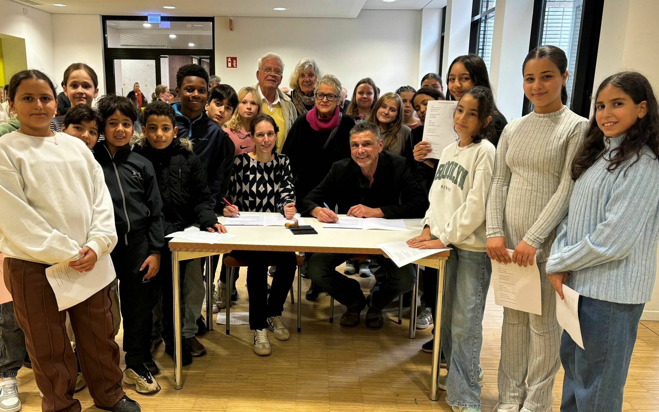 Eva Flader (Mitte links), Leitung der Begegnungsstätte Alt und Jung, und Schulleiter Uwe Heidelberg (Mitte rechts) unterzeichnen den Kooperationsvertrag.