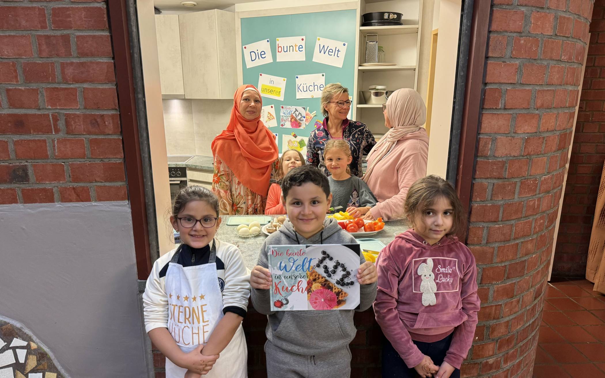  Die kleinen Mini-Köche: Fatima, Mohamed und Mariam (vorne v.li.) zusammen mit Ahlam Mohammed-Hamido, Gabriela Klosa und Nasija Abdelkader (hinten v.li.) zaubern gemeinsam im Kochclub des Kinder- und Jugendzentrums in Hochdahl köstliche Speisen auf die Teller. 