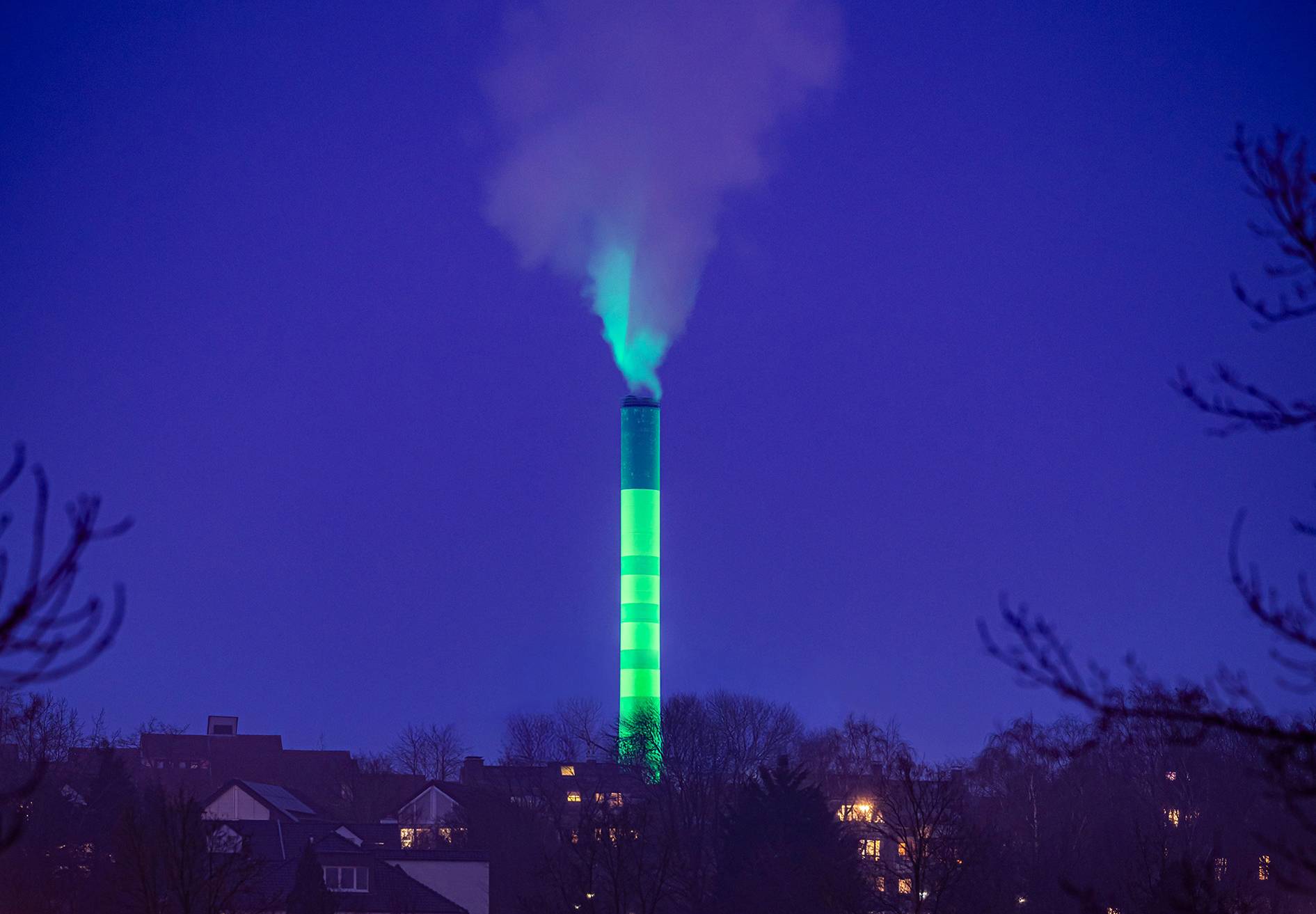  Der grün angestrahlte Schornstein - Blickfang und Symbol für die klimaneutrale Umgestaltung der Wärmeversorgung in Erkrath. 