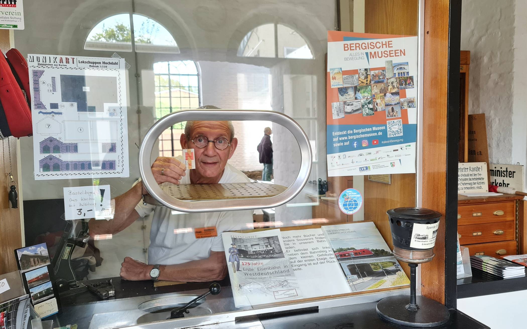  Uli Schimschock, Archivar im Heimatmuseum Lokschuppen Hochdahl, an der historischen Fahrkartenausgabe. 