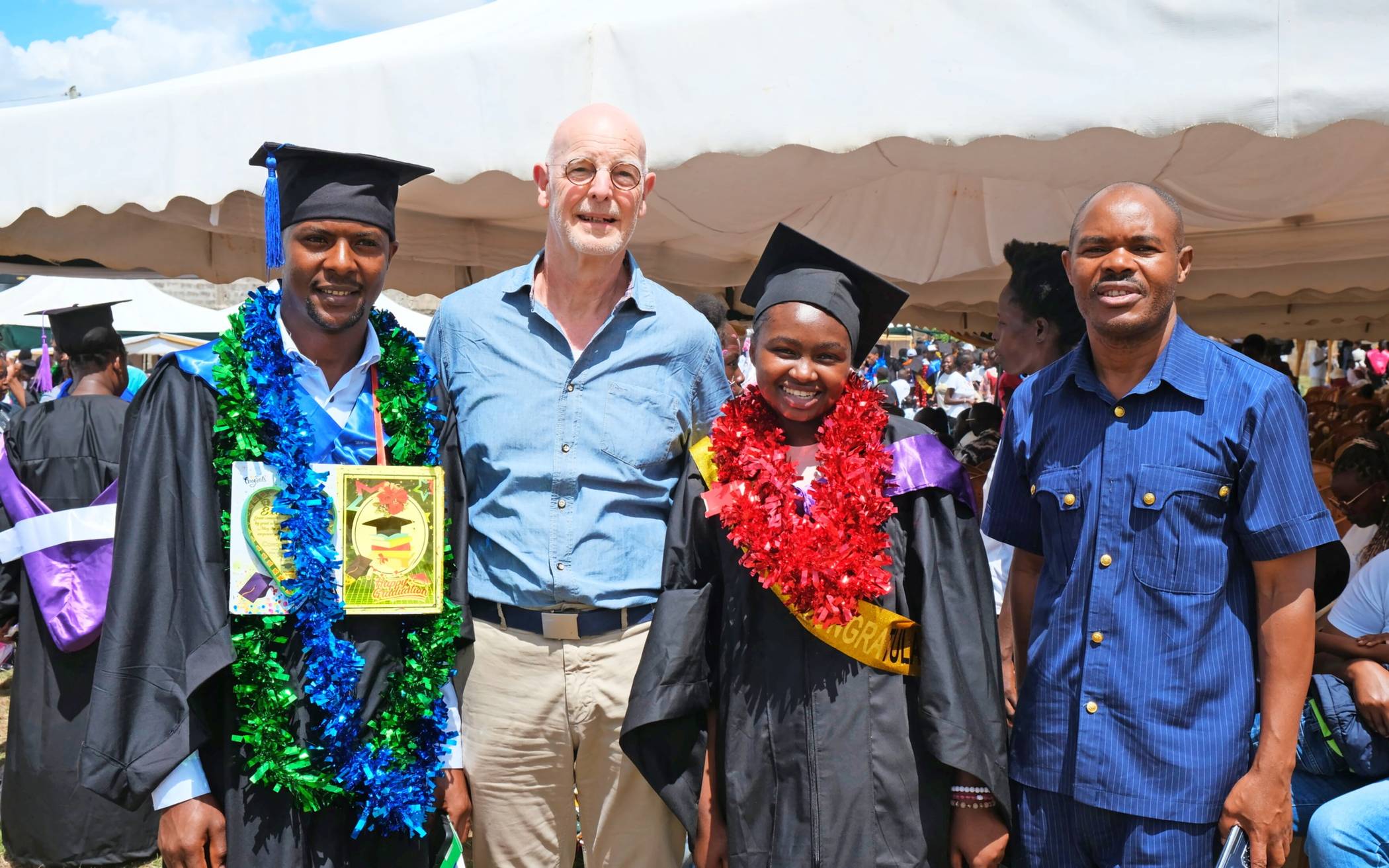Der Unterbacher Wim Dohrenbusch (2.v.li.) und John Kamande (Projektkoordinator von CoWA, re.) während der Graduierungsfeier am St. Kizito Vocational Training Institute mit zwei erfolgreichen AbsolventInnen (Solomon Mbugua, Kfz-Mechanik, und Cecilia Wambui, Hauswirtschaft).  