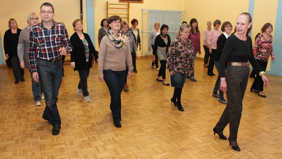  Tanzlehrerin Ulrika Missalla (re.) zeigt den Teilnehmern wie man seine Füße beim „Line Dance“ richtig sortiert, damit am Ende eine Choreographie heraus kommt. 