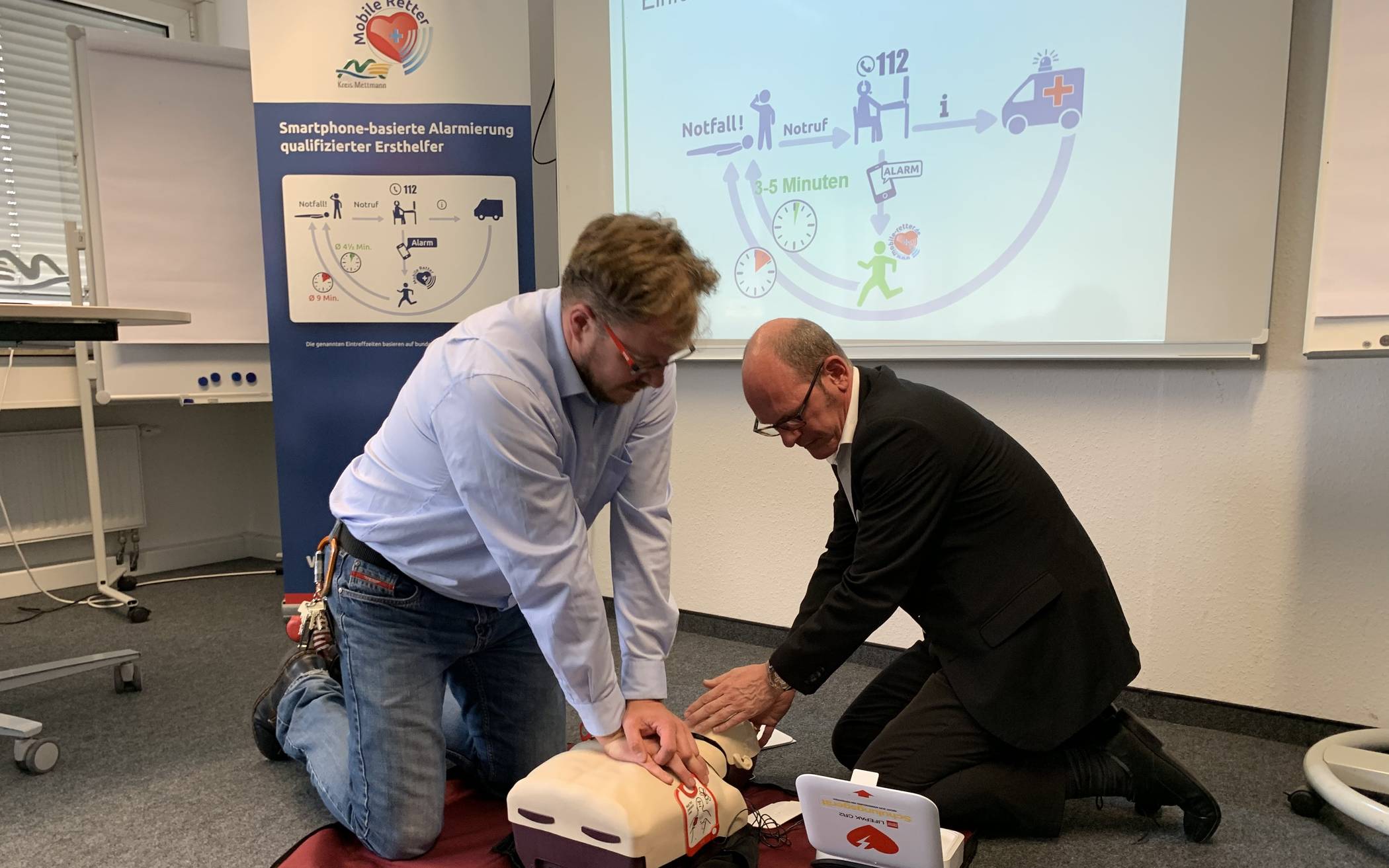  Bastian Etti von der Bildungsakademie und der ärztliche Leiter des Rettungsdienstes, Dr. Arne Köster, demonstrieren die Wiederbelebung mittels Herzdruckmassage. 