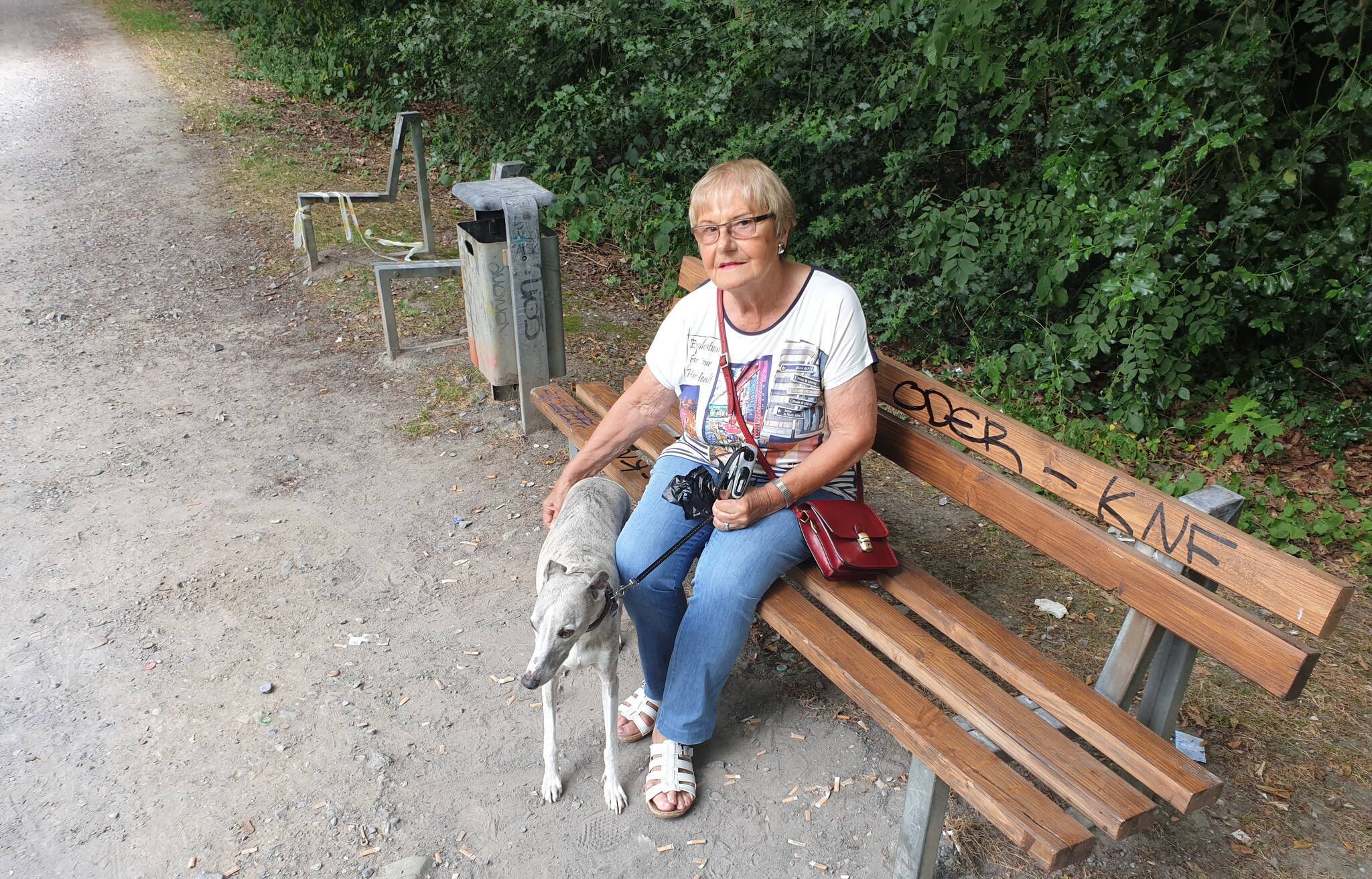  Karin B. auf besagter Bank, die zum Sitzen durch die schmalen Kanthölzer ziemlich unbequem ist. Daneben steht nur noch das Gerippe einer mal intakten Sitzbank. 